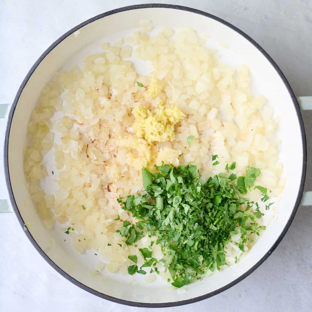 Onions after cooking until soft and translucent with ginger, garlic and cilantro added before combining.