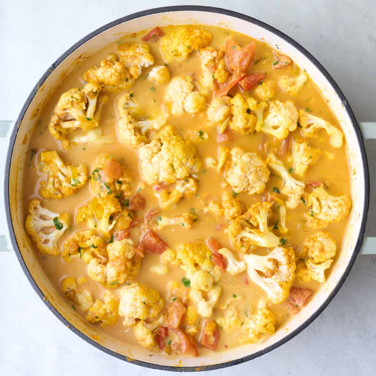 Tomatoes and coconut milk added on top after stirring.