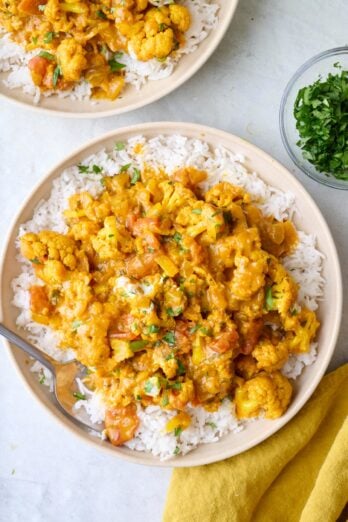 Cauliflower curry served over rice in a bowl.