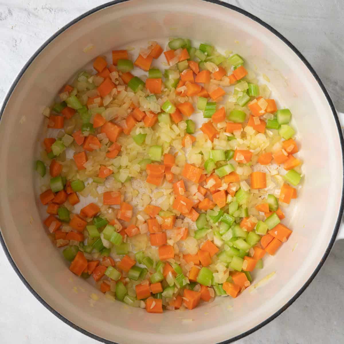 Pot with cooked onions, carrots, celery and garlic.