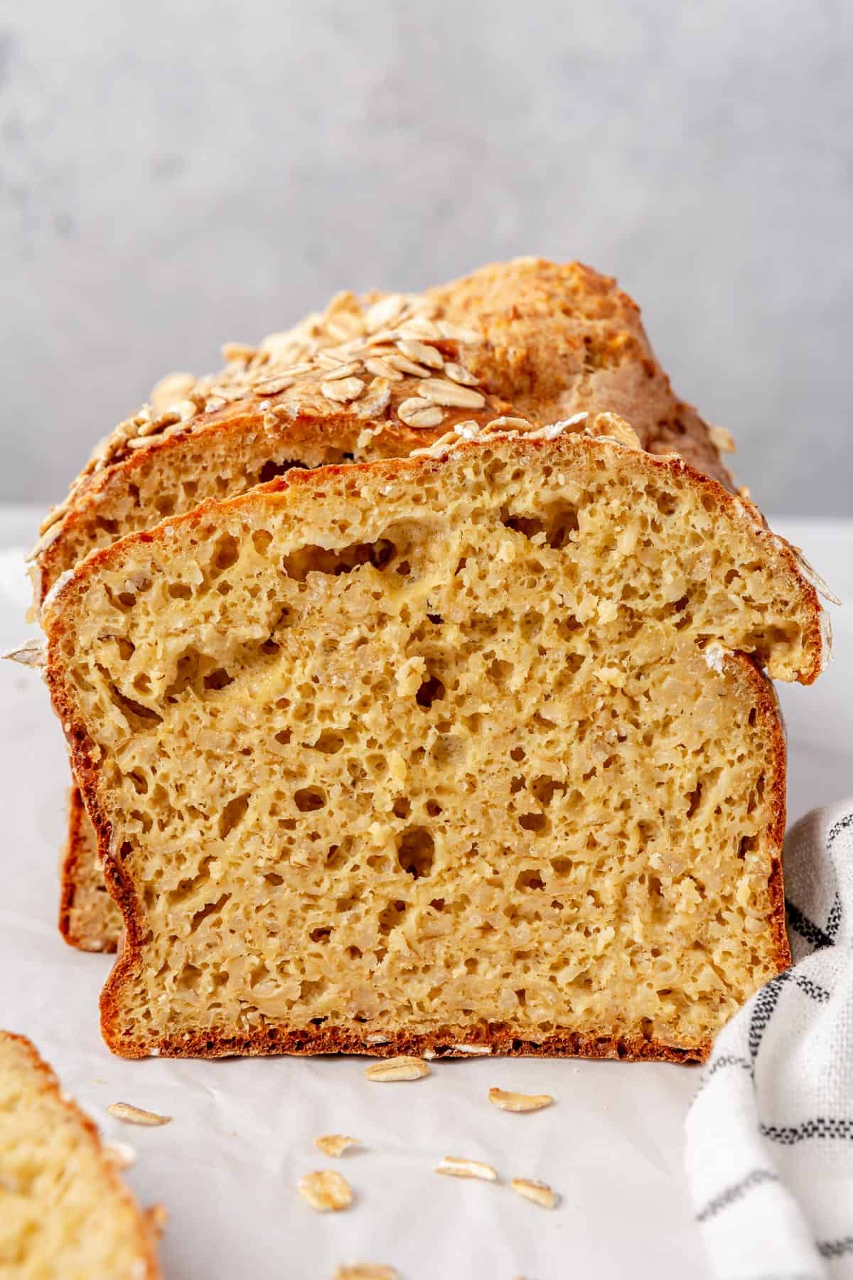 Slice of 5 ingredient cottage cheese bread to show inside texture with whole loaf behind.