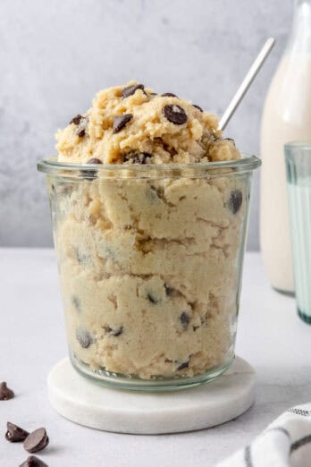 Cottage cheese cookie dough overfilled in a small serving glass with spoon inside.