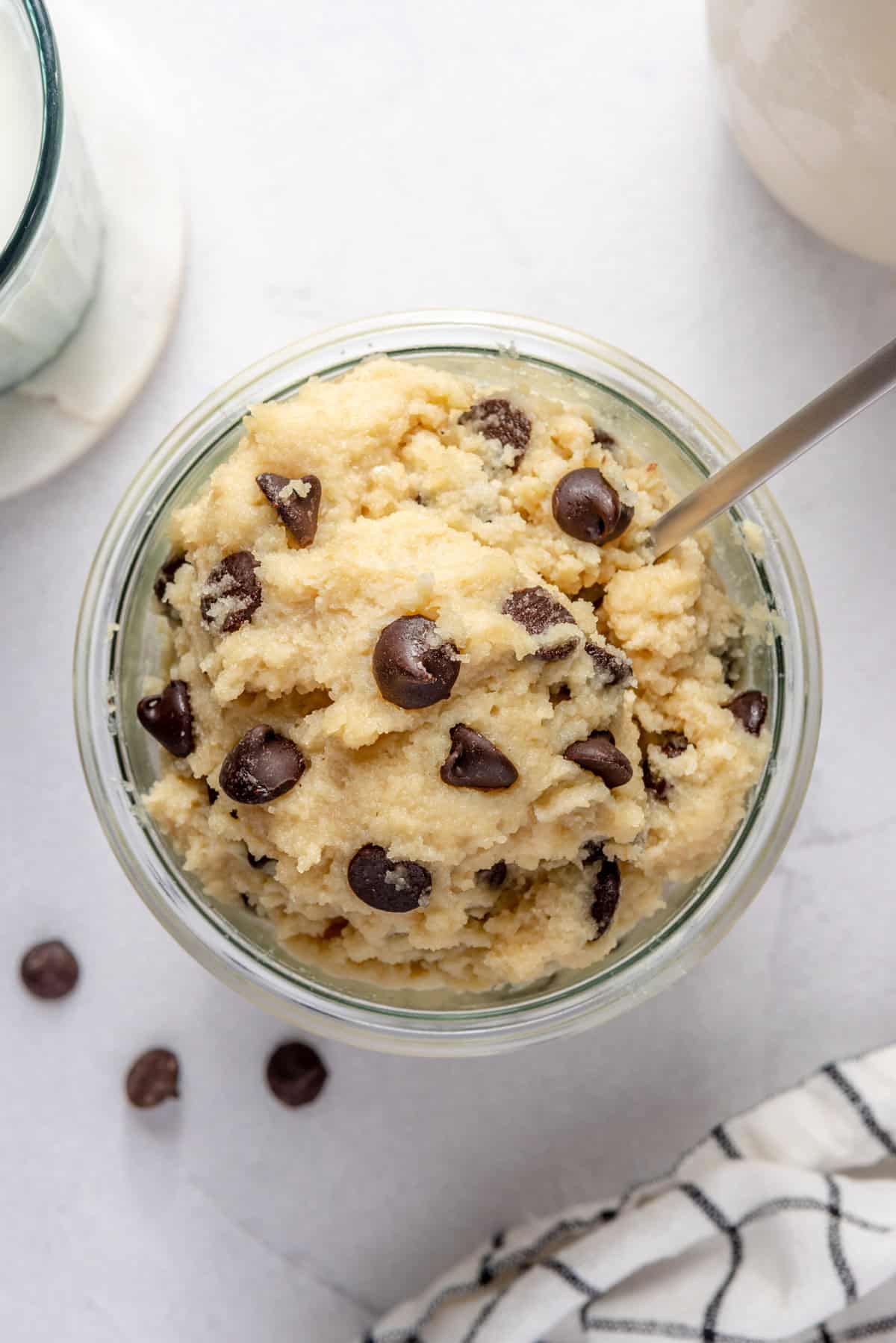 Edible cottage cheese cookie dough in glass jar, with spoon dipping in.