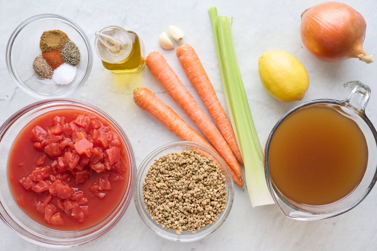 Ingredients for recipe: Spices, canned tomatoes, dry green lentils, oil, carrots, celery, garlic, lemon, vegetable broth, and onion.