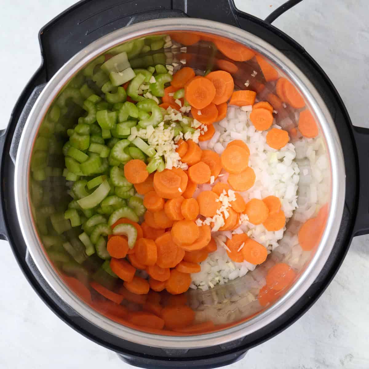 Onions, carrots, celery and garlic in an Instant Pot.