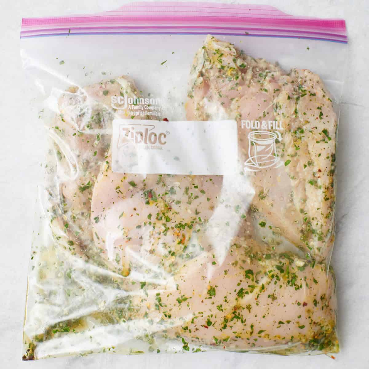 Chicken breast marinating in a bag.