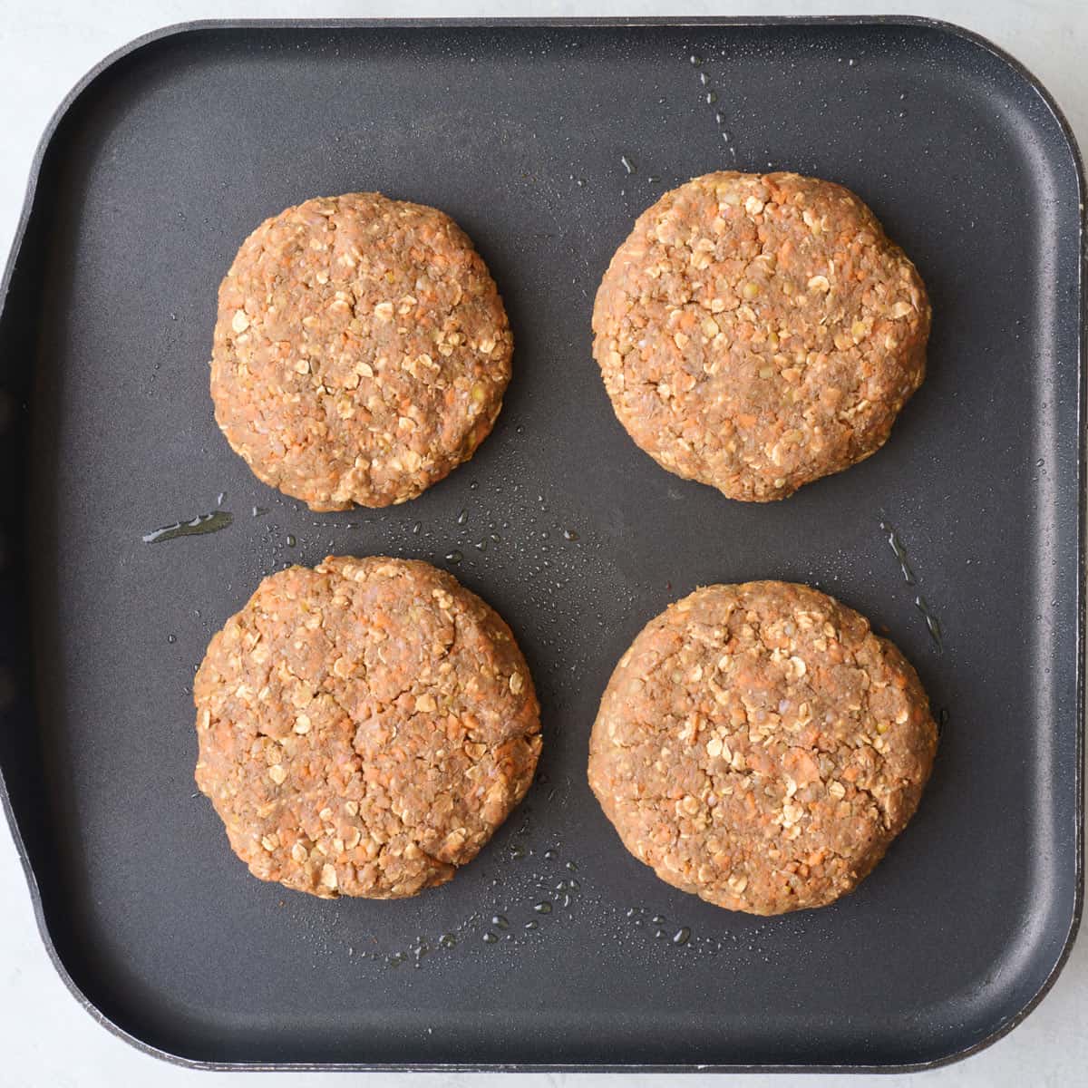 4 patties on a skillet.