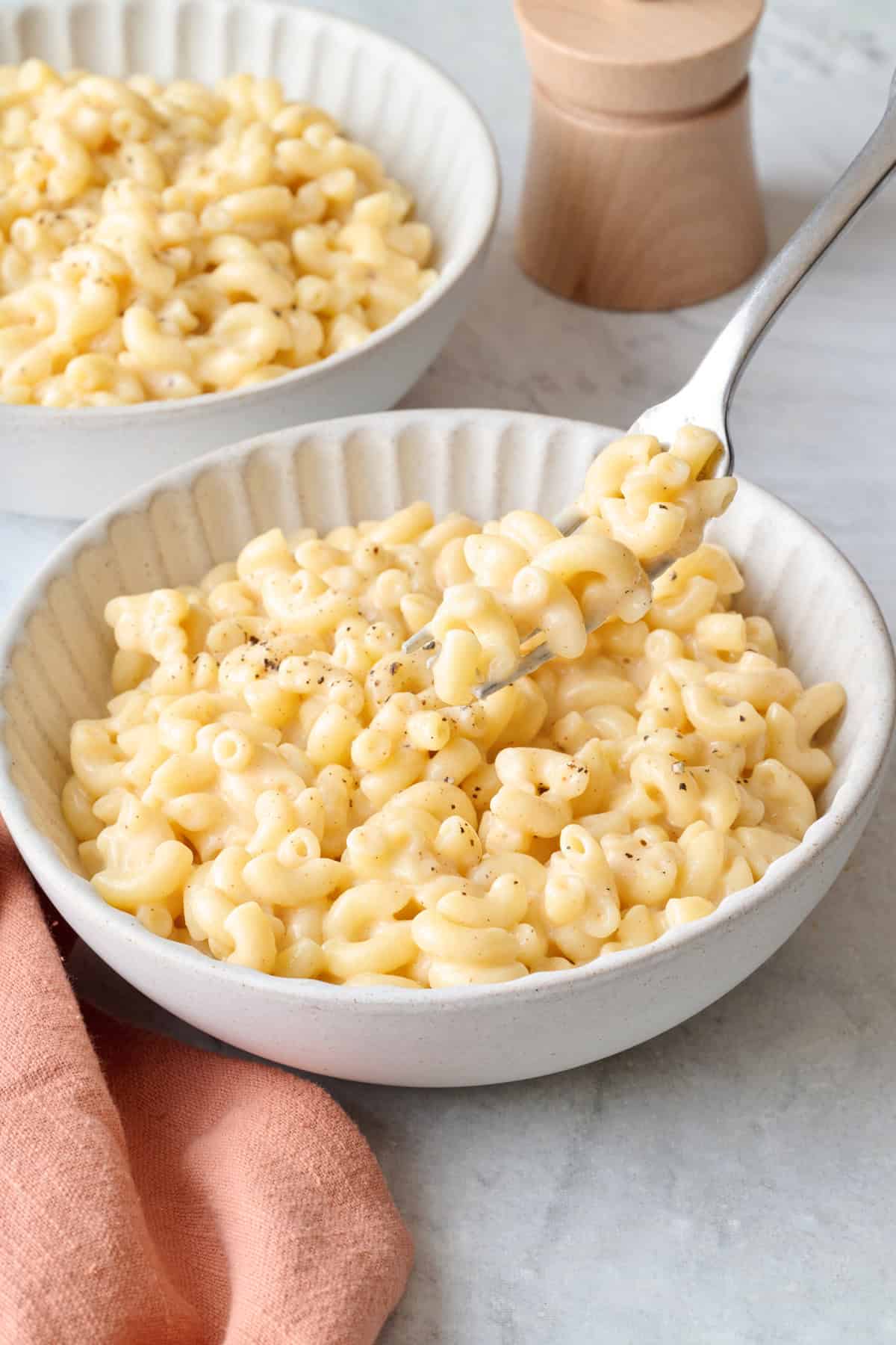 Cottage cheese macaroni in a bowl with a fork lifting up a bite.