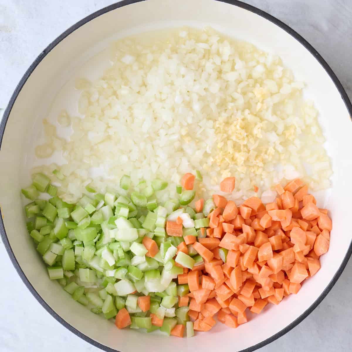 Chopped veggies and garlic in a pot.