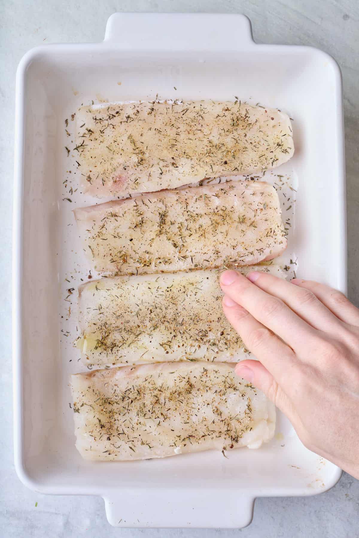 Rubbing spice blend onto fish.