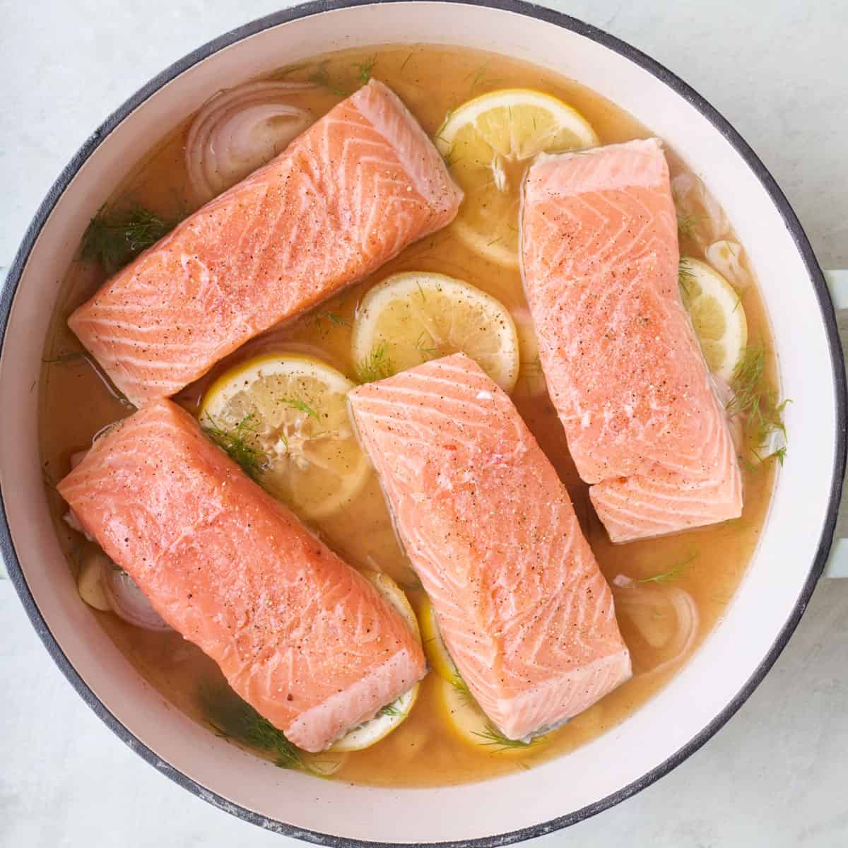 After simmering liquid with salmon fillets placed on top, skin side down, seasoned with salt.