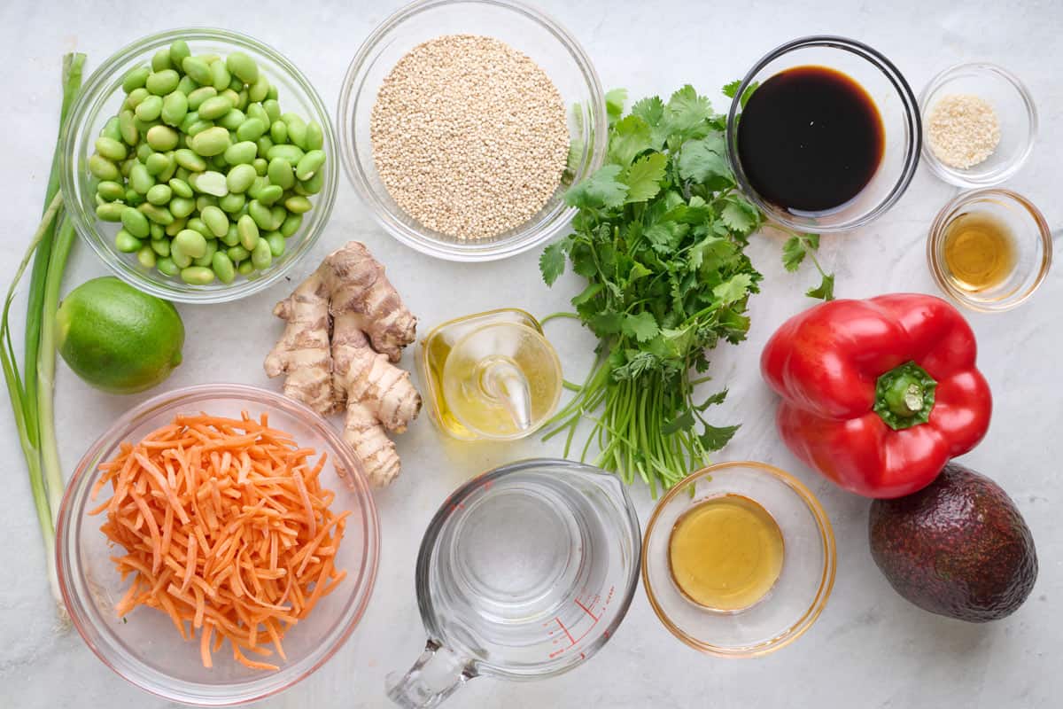 Ingredients for recipe: edamame, green onions, lime, shredded carrots, ginger, quinoa, cilantro, oil, water, honey, soy sauce, sesame seeds, olive oil, red pepper, and avocado.