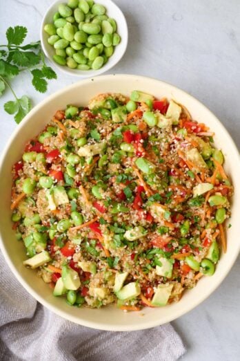 Quinoa edamame salad in a serving bowl with a small dish of more edamame nearby.