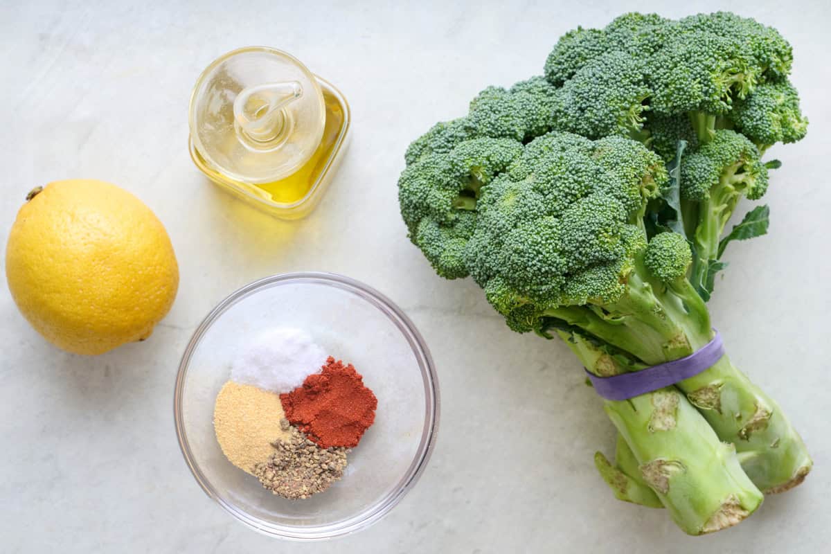 Ingredients for recipe: head of broccoli, oil, spice blend, and lemon.