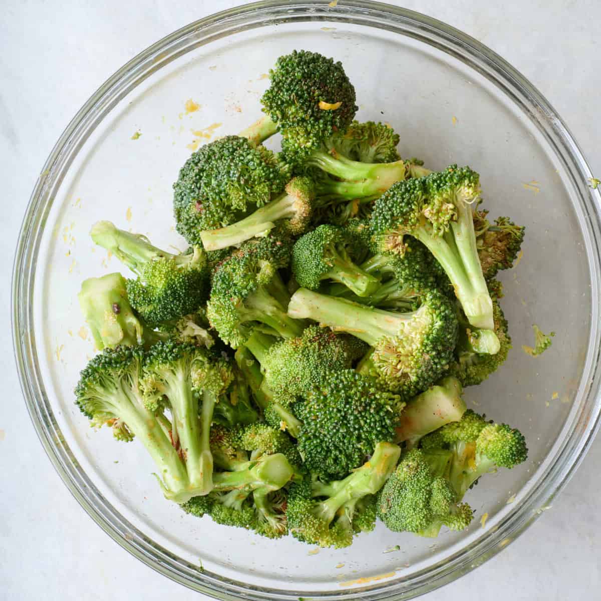 Seasoned broccoli florets in a bowl.