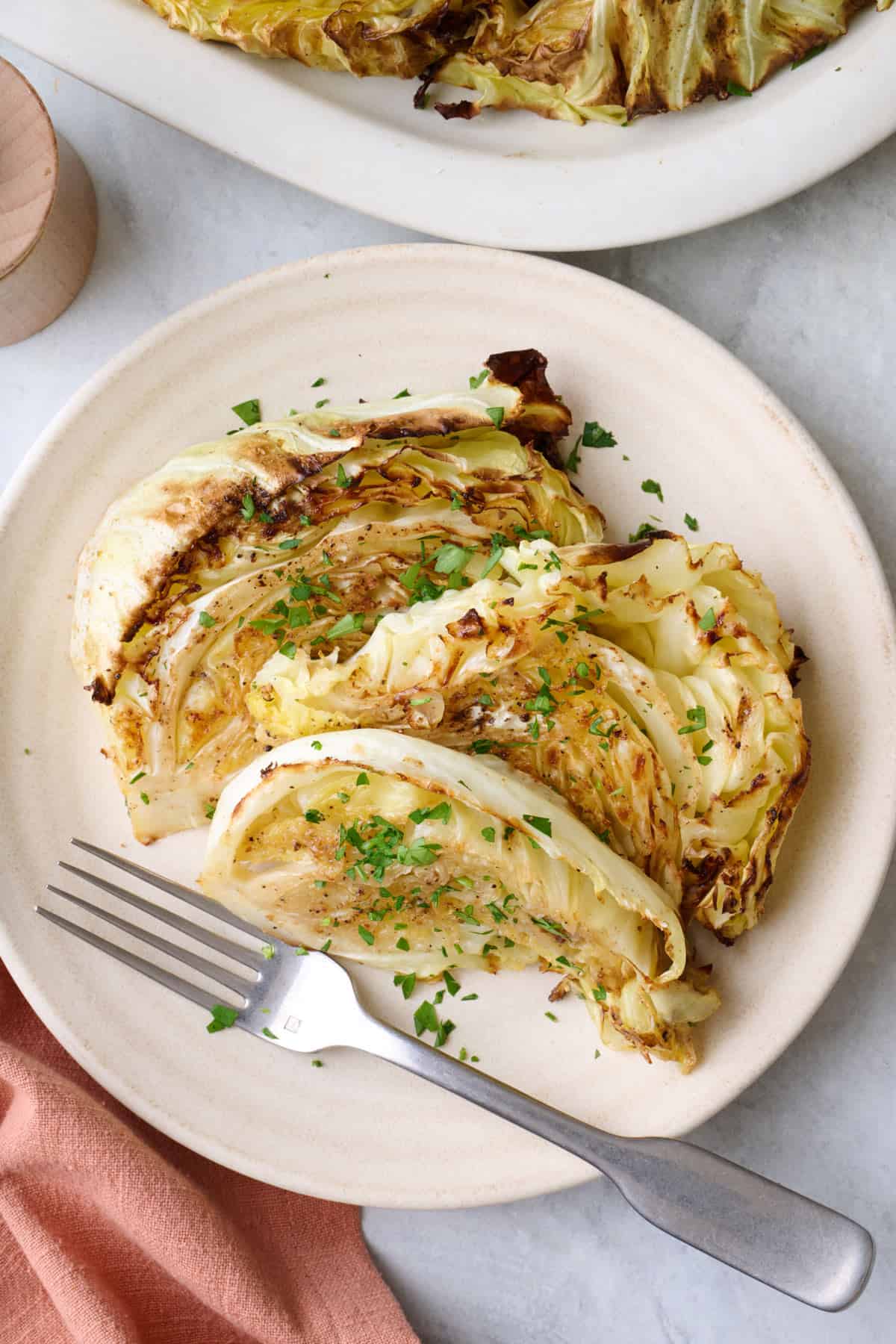 Roasted cabbage wedges on a plate.