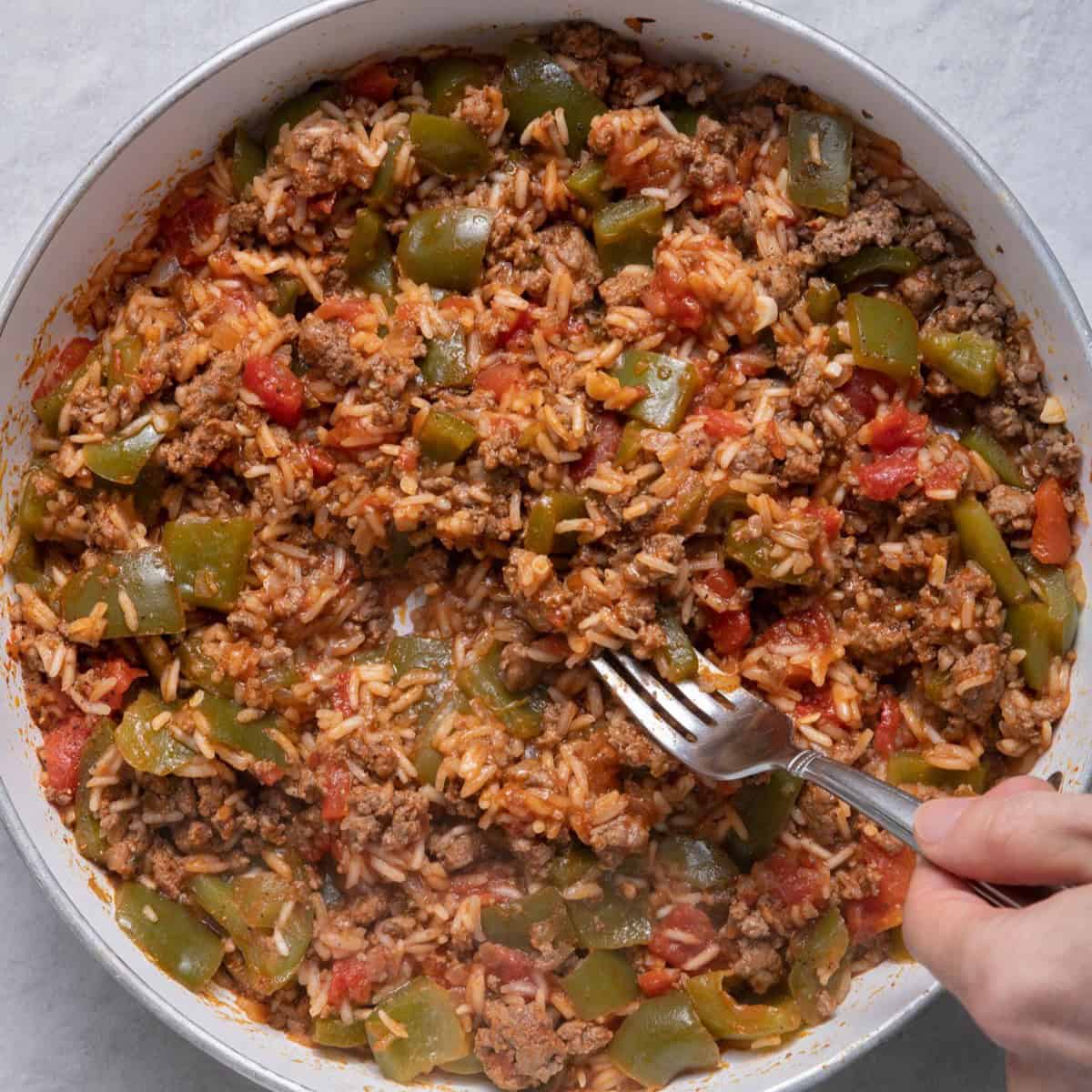 Mixing rice into beef and tomato mixture.