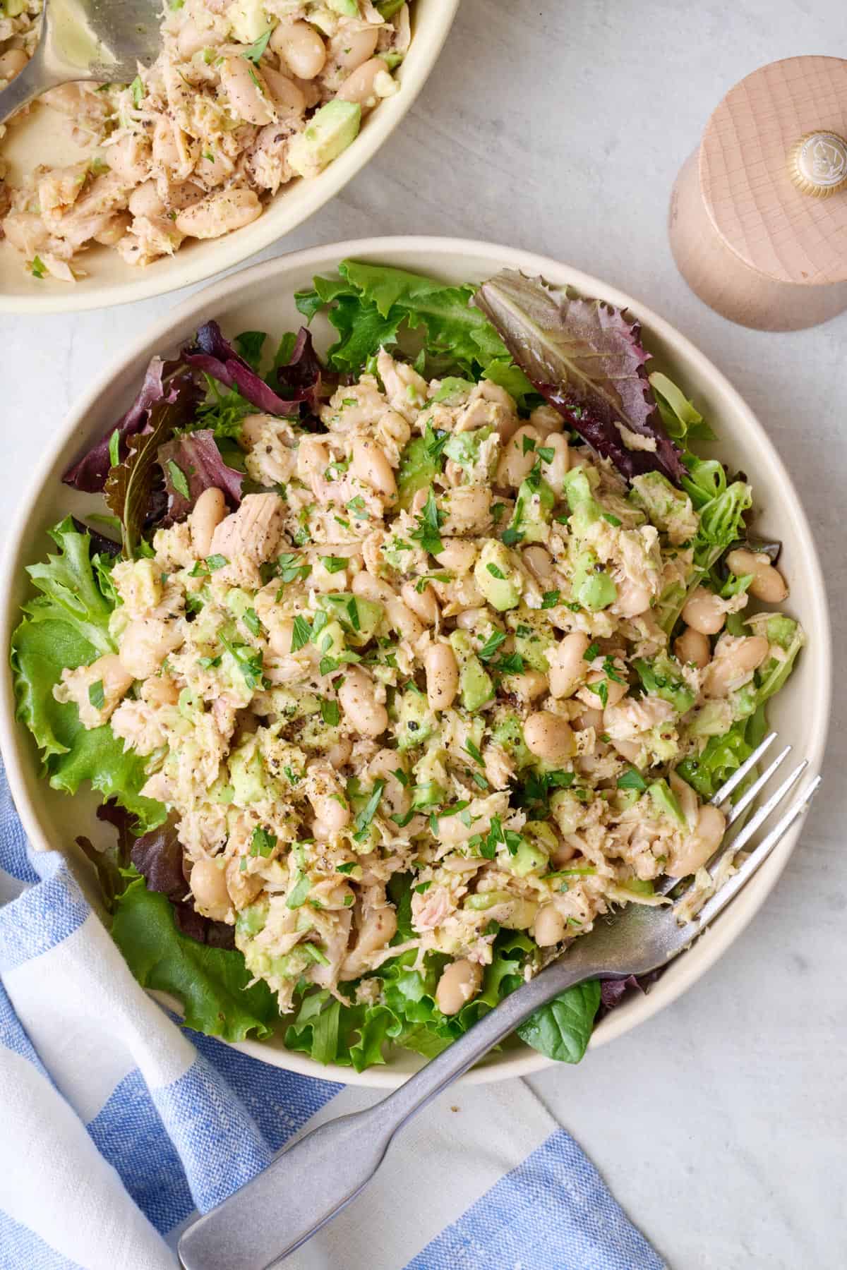 Easy white bean tuna salad served over mixed greens in a bowl.