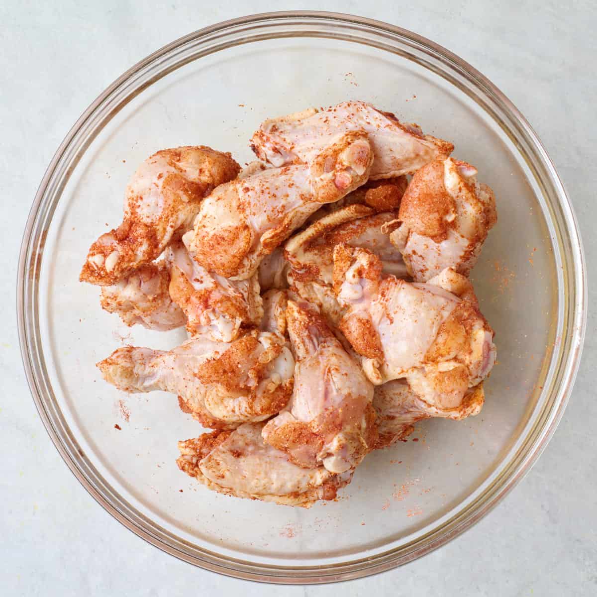 Seasoned chicken wings in a bowl.