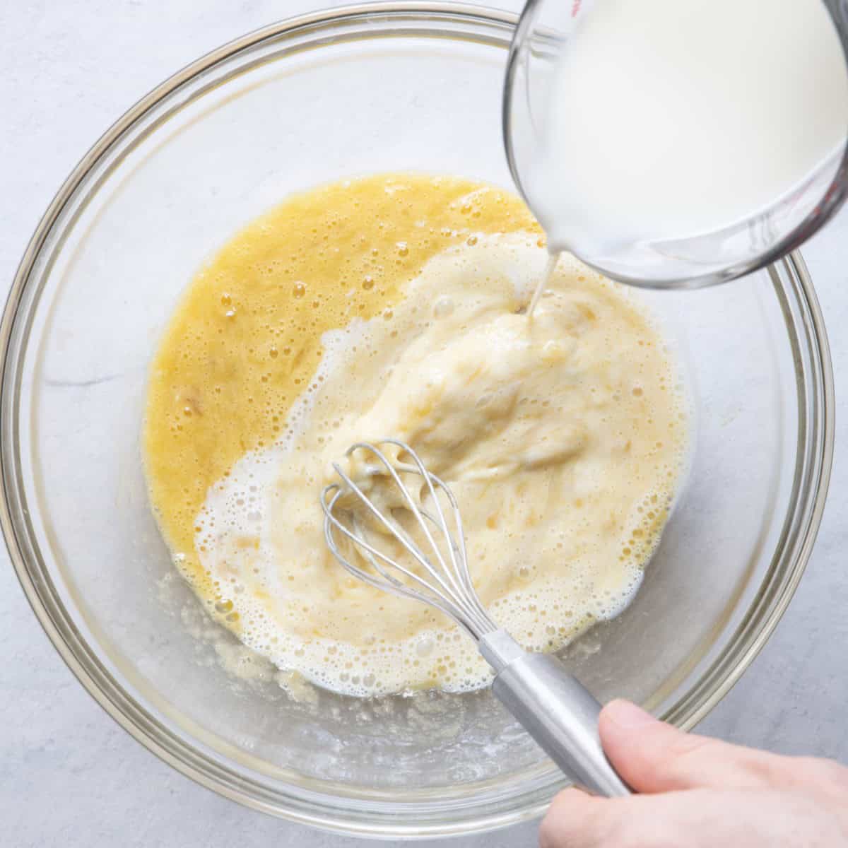 Whisking milk into banana egg mixture.