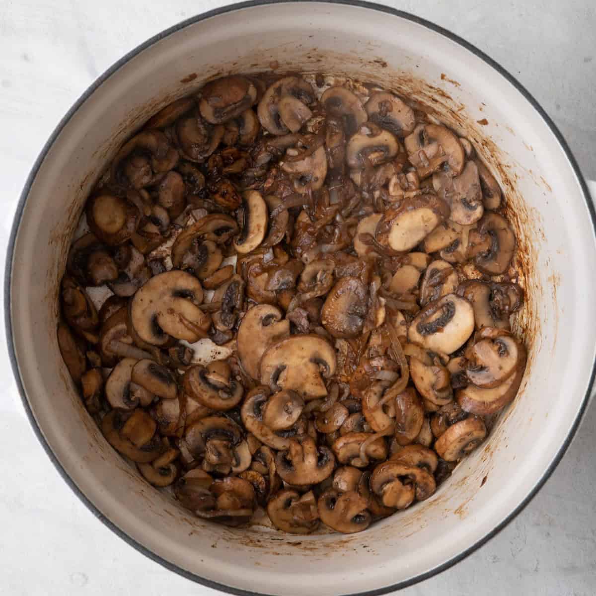 Mushrooms and onions after sauteed to show browned caramelization after deglazing with apple cider vinegar.