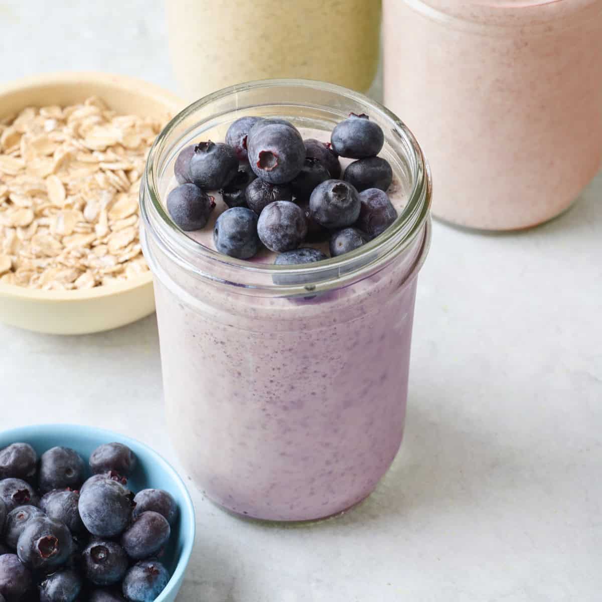 Blueberry blended overnight oats in a small jar topped with fresh blueberries.