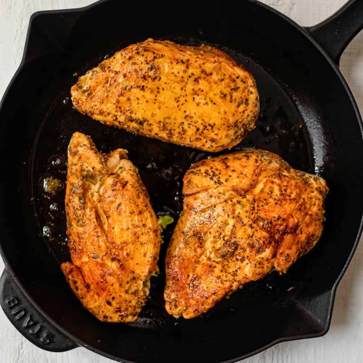 Chicken after flipping in skillet.