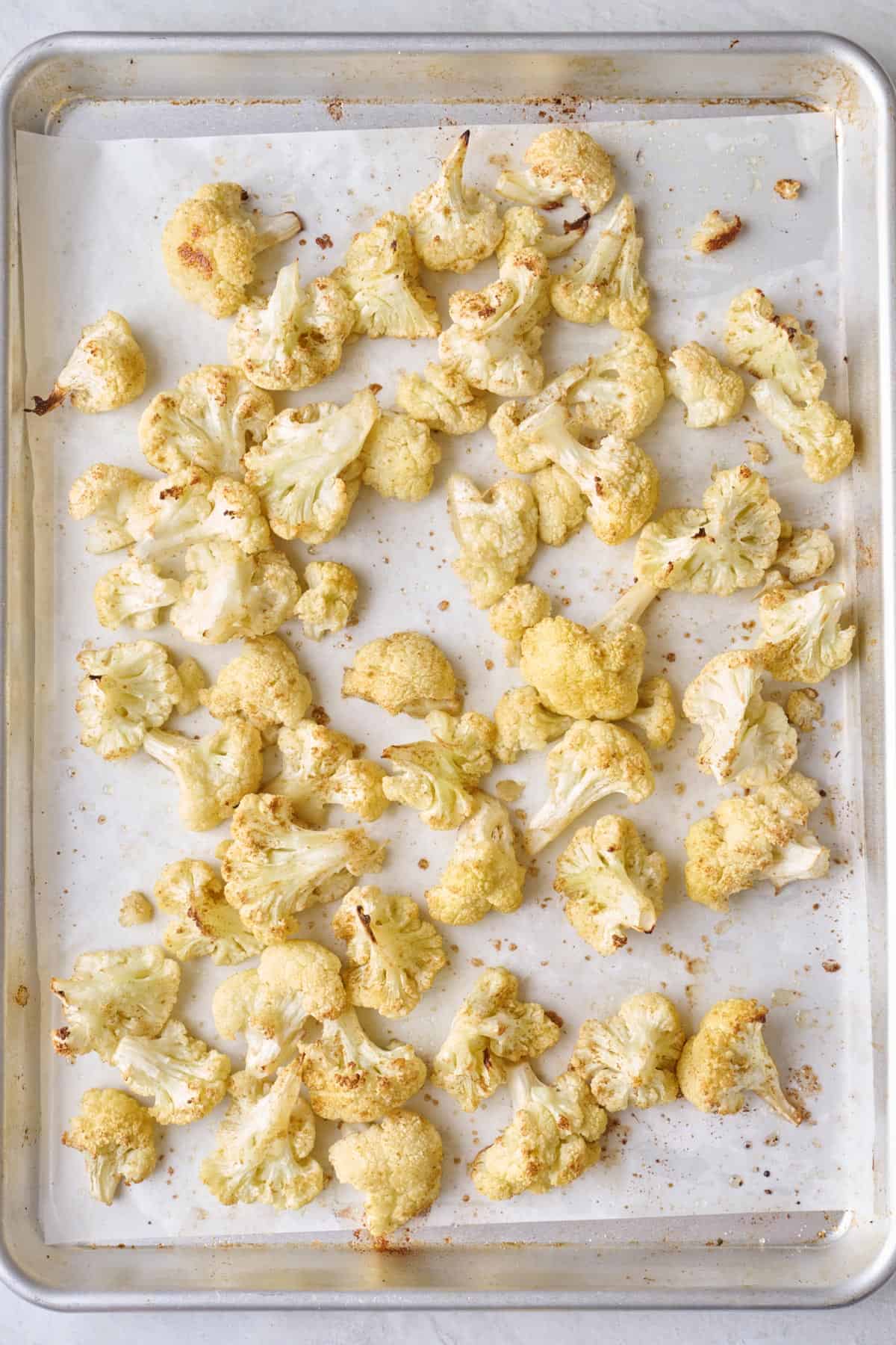 Roasted cauliflower florets on a sheet pan.