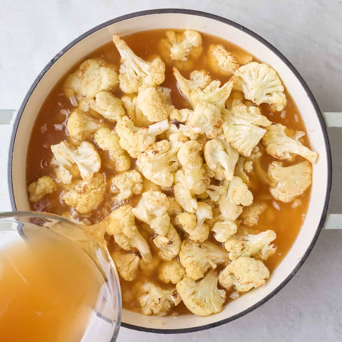 Broth and roasted cauliflower added to pot.