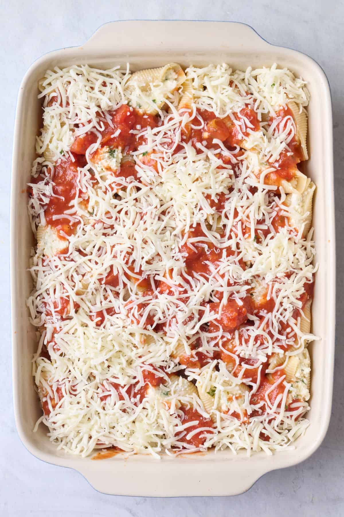 Remaining sauce and cheese added on top before baking.