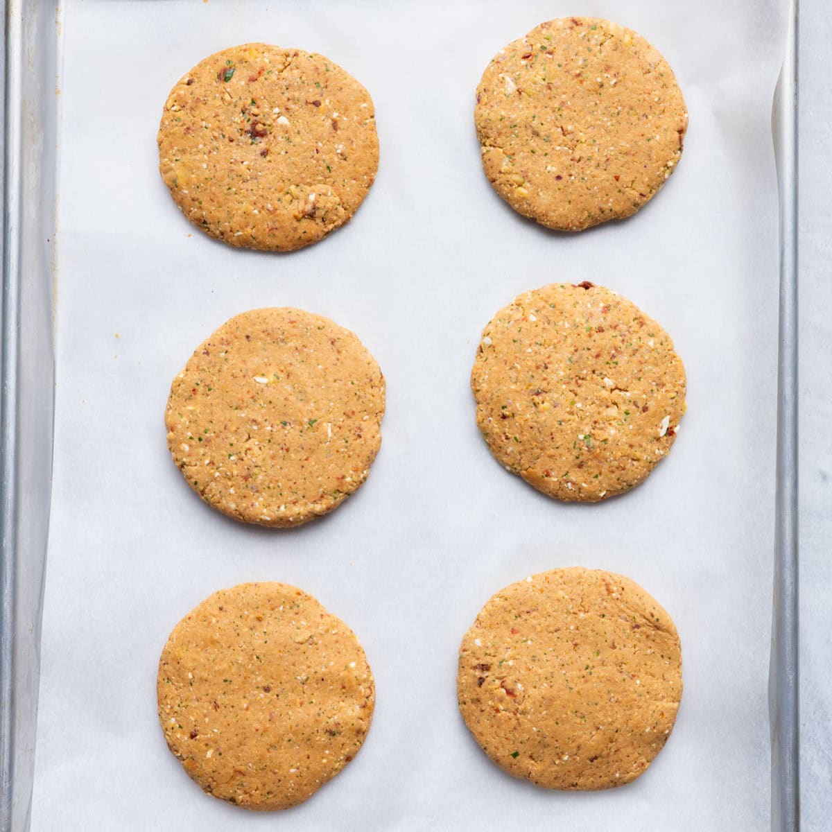 Chickpea patties formed and placed on a sheet pan.