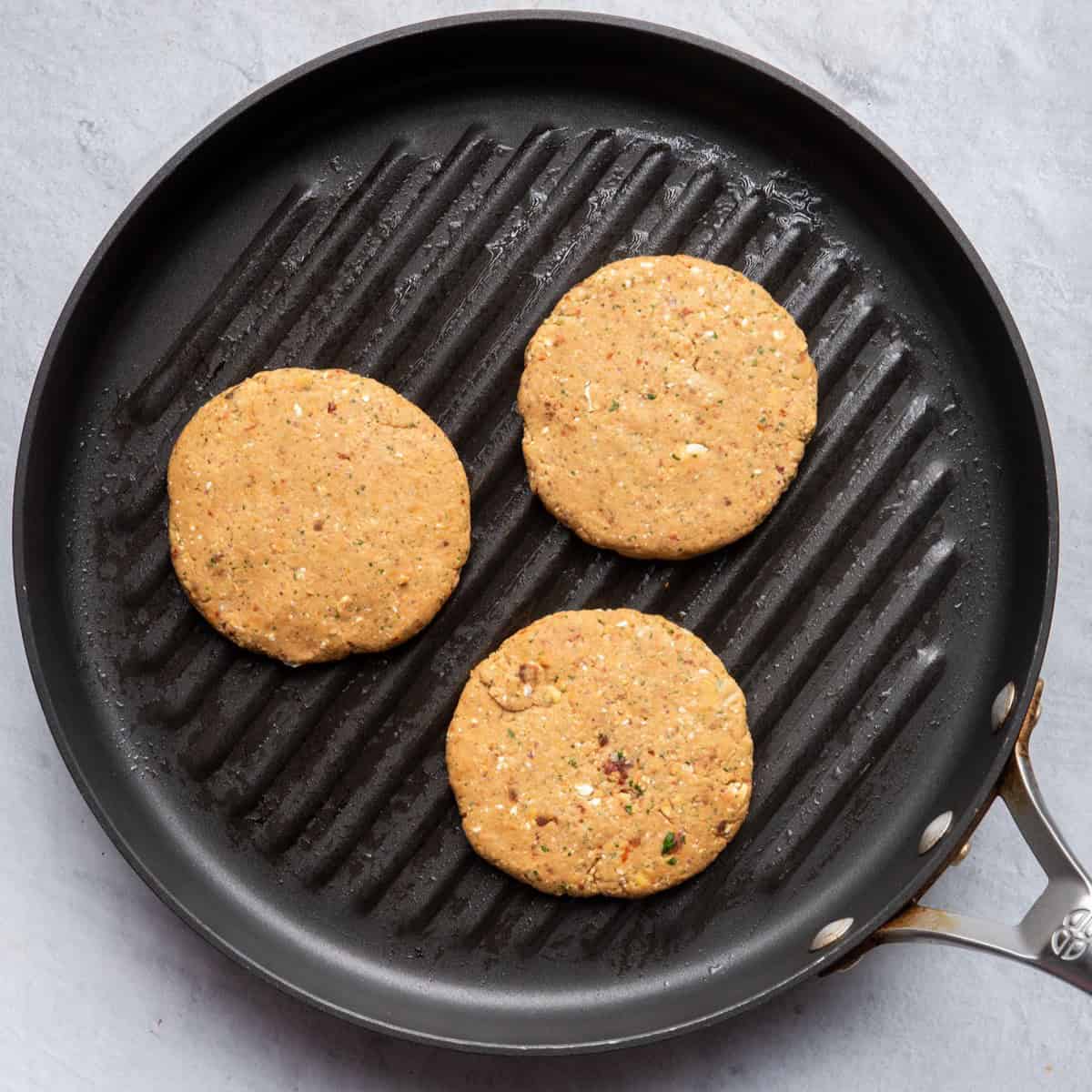 Three patties on a grill pan.