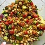 Easy crispy rice salad with chickpeas, tomatoes, olives, cucumbers, onions and a citrus salad dressing.