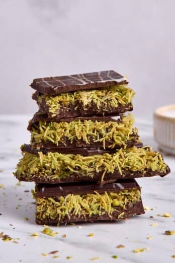 A few thick pieces of Dubai chocolate bar stacked on top of each other to show pistachio filling.