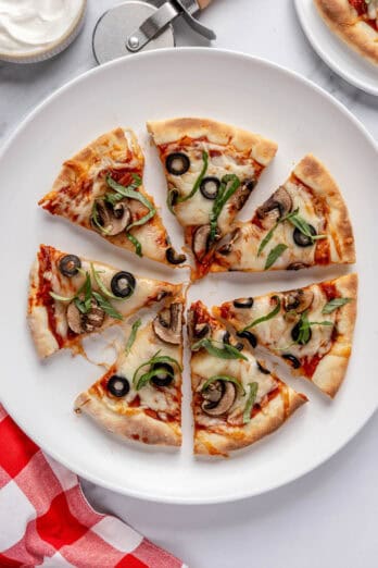 Pizza cut into 8 slices on a round plate.