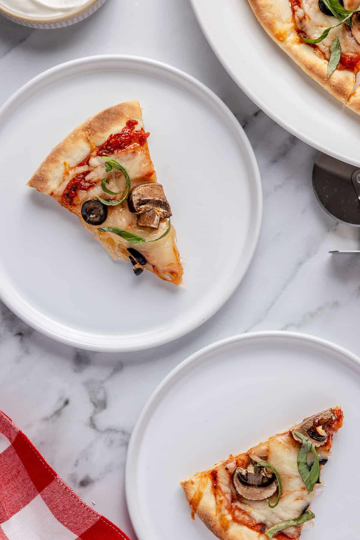 Greek yogurt pizza dough pizza slices on two plates.