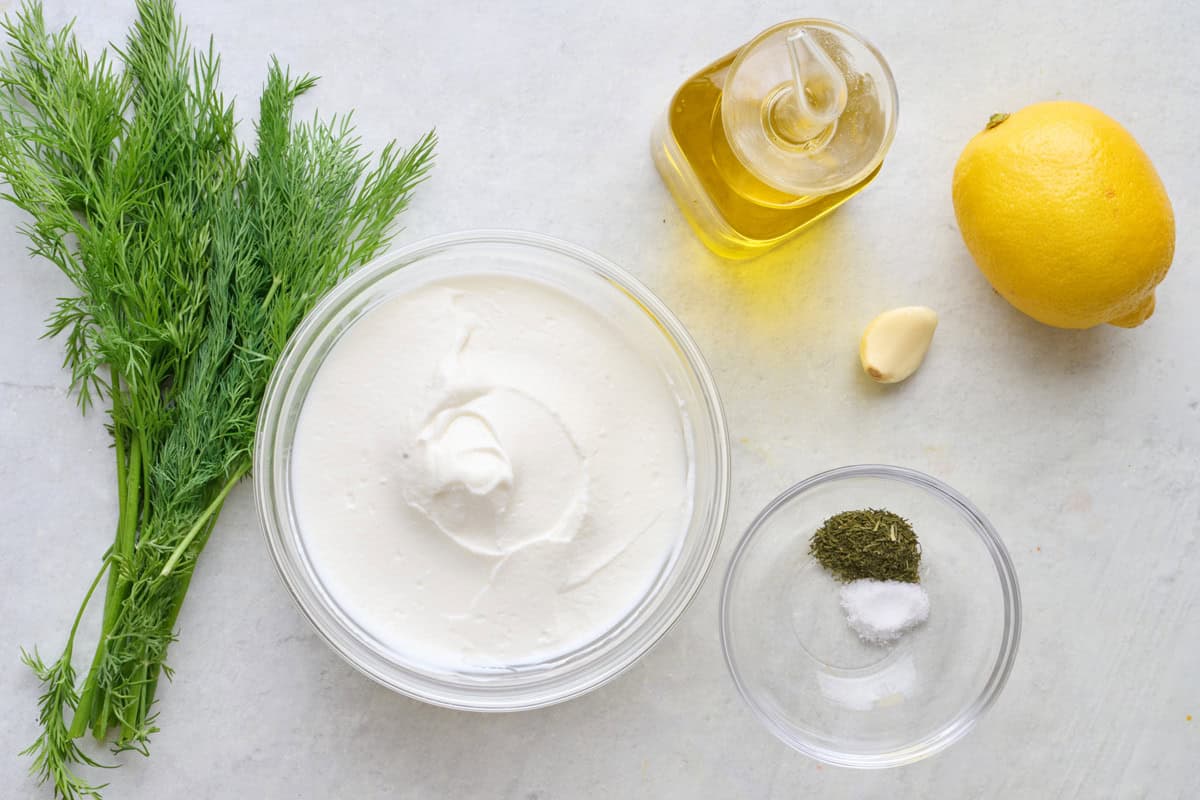 Ingredients for recipe: Greek yogurt, fresh dill, dill powder, salt, olive oil, garlic, and lemon.