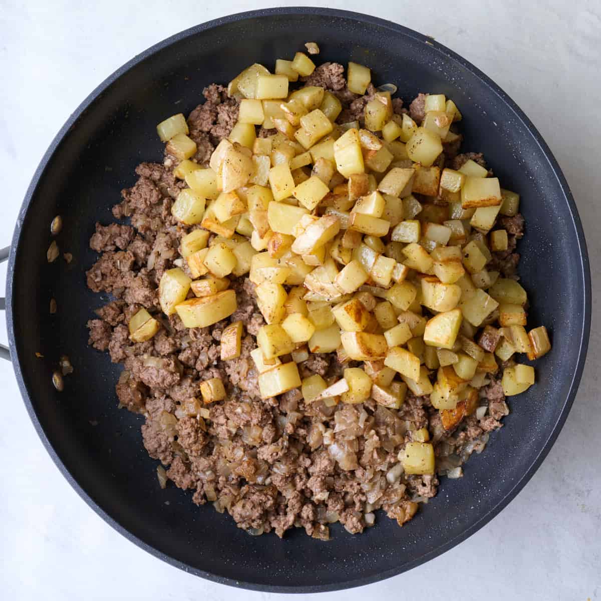 Potatoes added on top beef mixture.