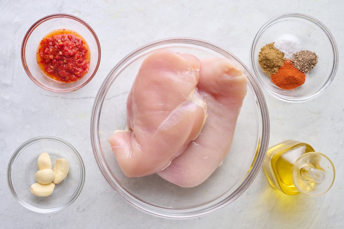 Ingredients for recipe: harissa, garlic, chicken breasts, spices, and oil.