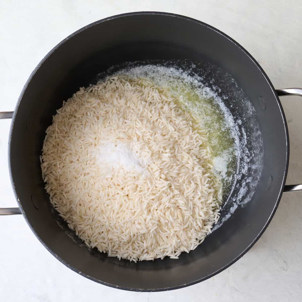 Melted butter, rinsed rice, and salt in a pot.