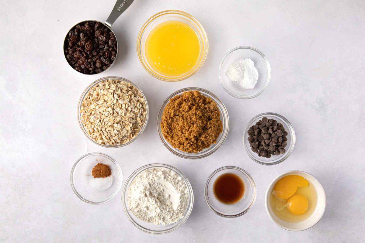 Ingredients for recipe: raisins, oats, melted butter, brown sugar, baking soda, baking powder, salt, cinnamon, flour, vanilla, eggs, and chocolate chips.