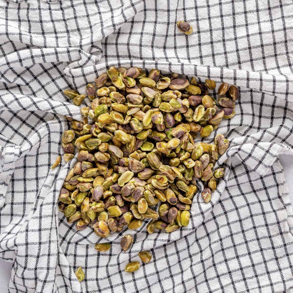 Pistachio after soaking and strained, drying on a tea towel.