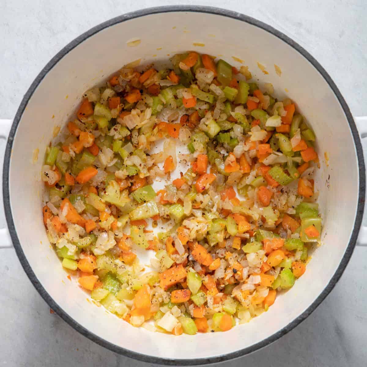 Onions, carrots, and celery with seasonings after cooking.