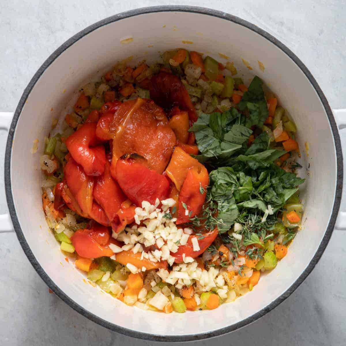 Garlic, basil, thyme and roasted red peppers added to pot.