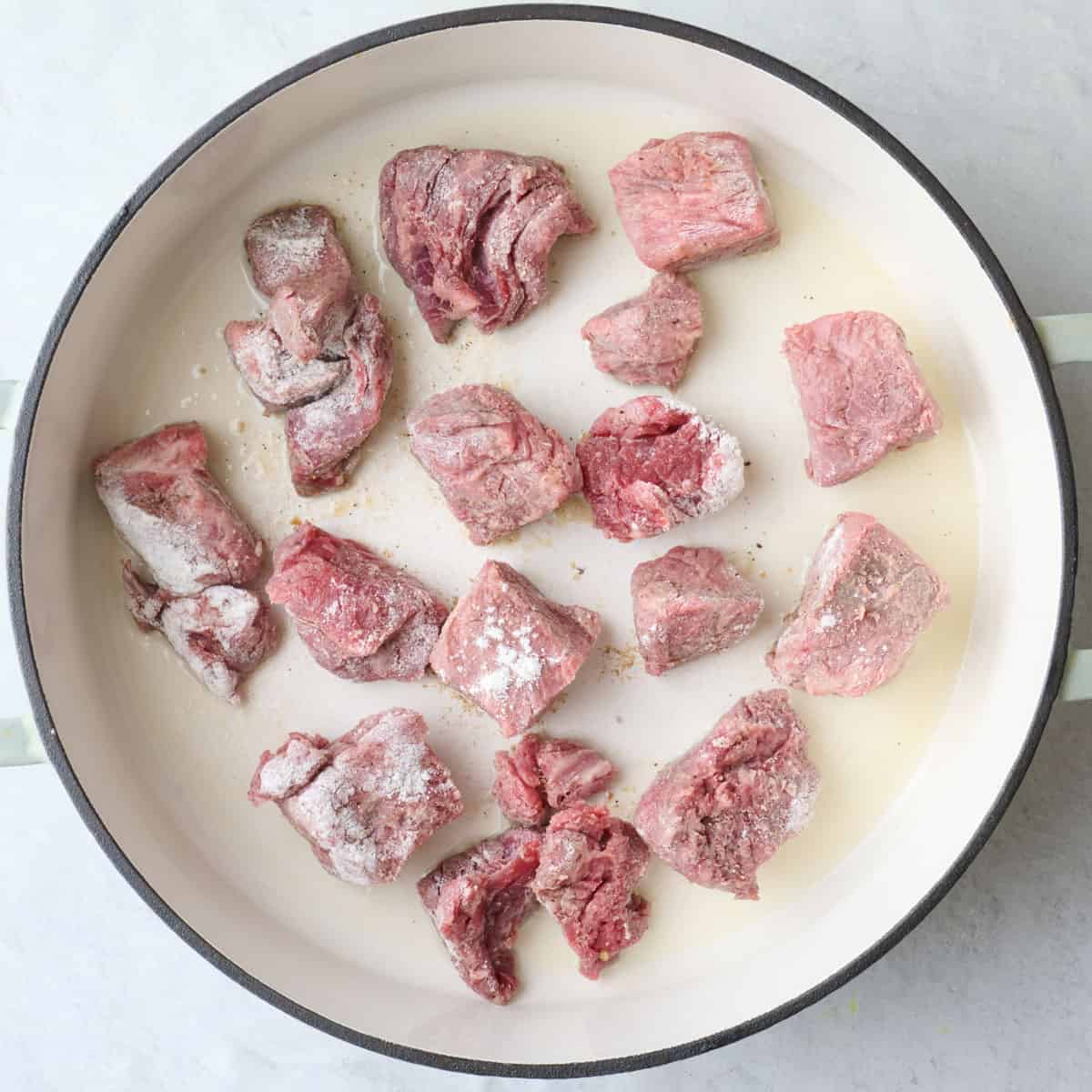 Flour coated stew meat in a hot oiled skillet.