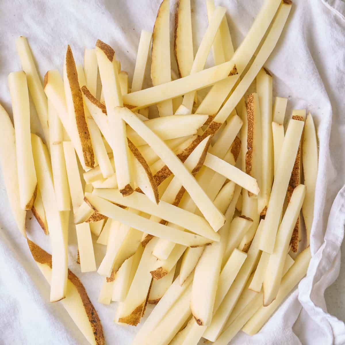 Drying potatoes on a clean kitchen towel.