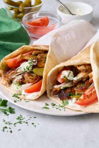 Homemade chicken shawarma wrapped in pitas with toppings.