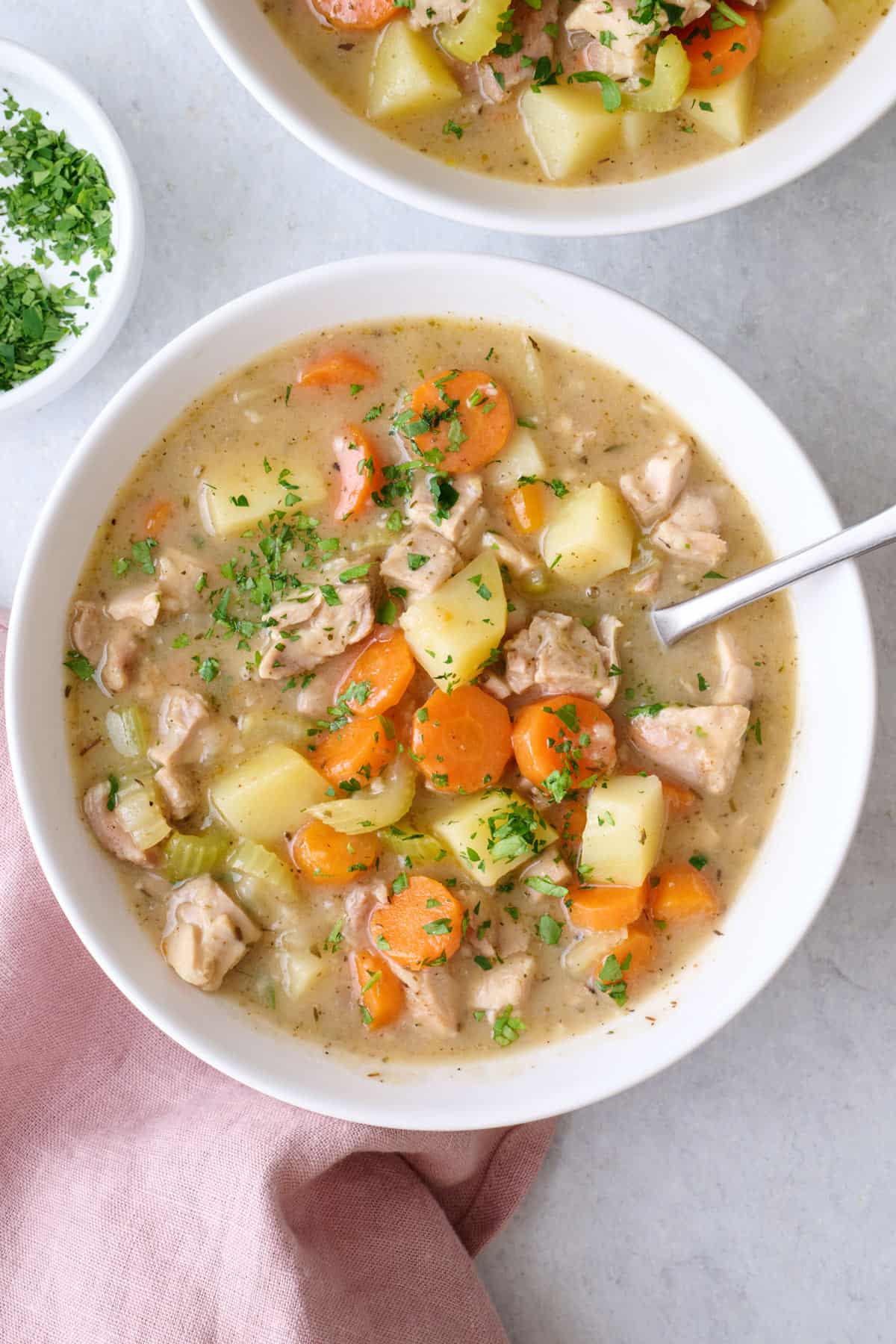Easy homemade chicken stew with chicken thighs, carrots, celery, and potatoes, in a bowl.