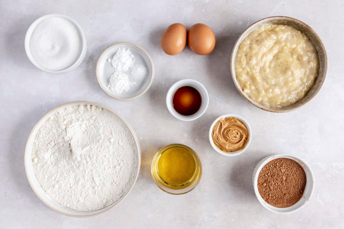 Ingredients for recipe: sugar, baking powder, baking soda, salt, flour, vanilla, oil, peanut butter, chocolate and mashed bananas.