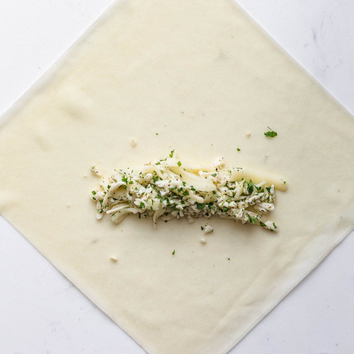 Open spring roll wrapper filled with mixed cheese blend.